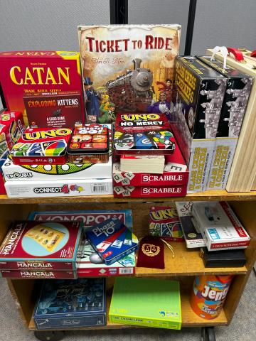Board games, including Catan, Ticket to Ride, Uno No Mercy, and Trouble